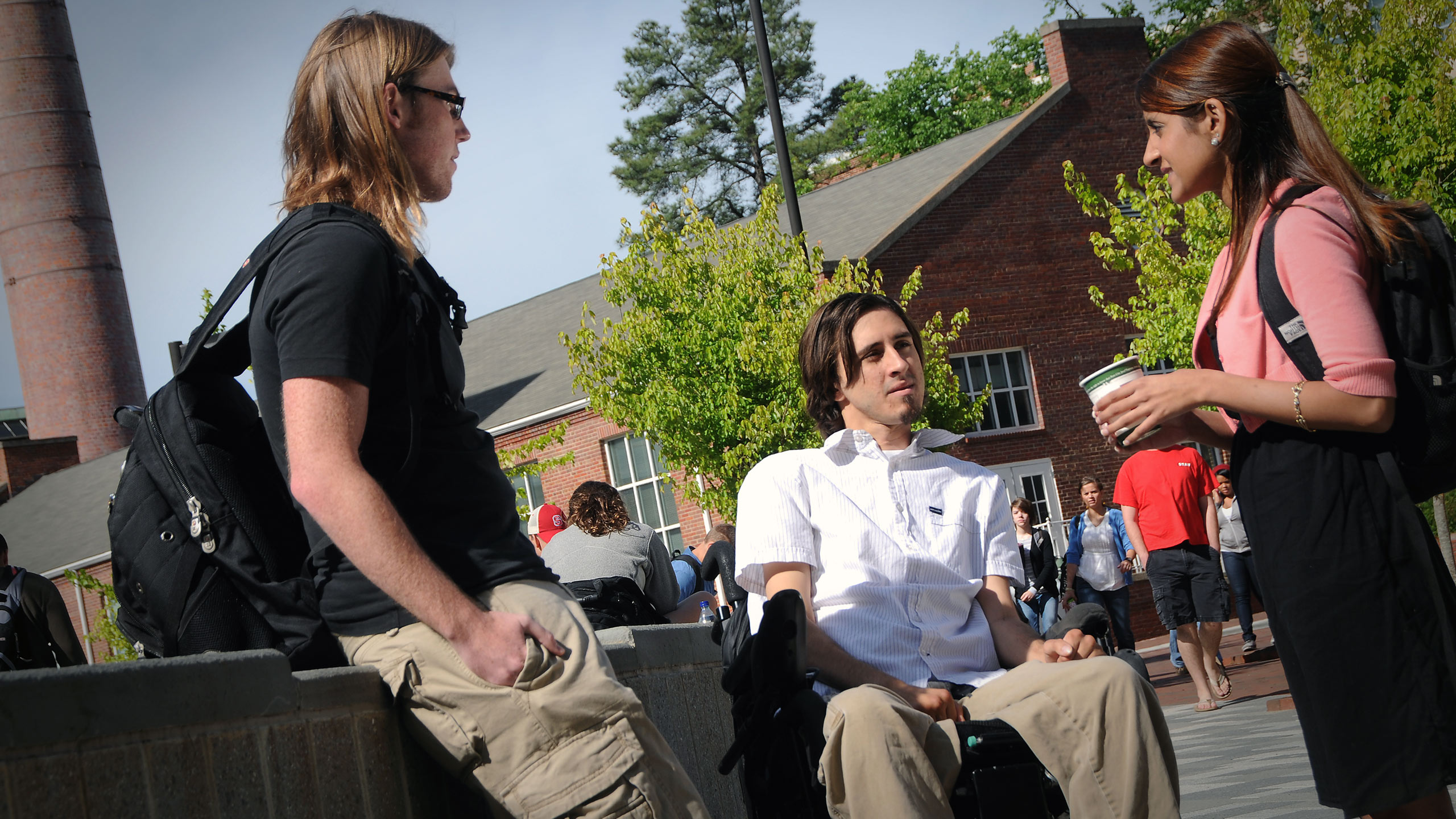Three students outside in a courtyard discussing the MIMSE admissions